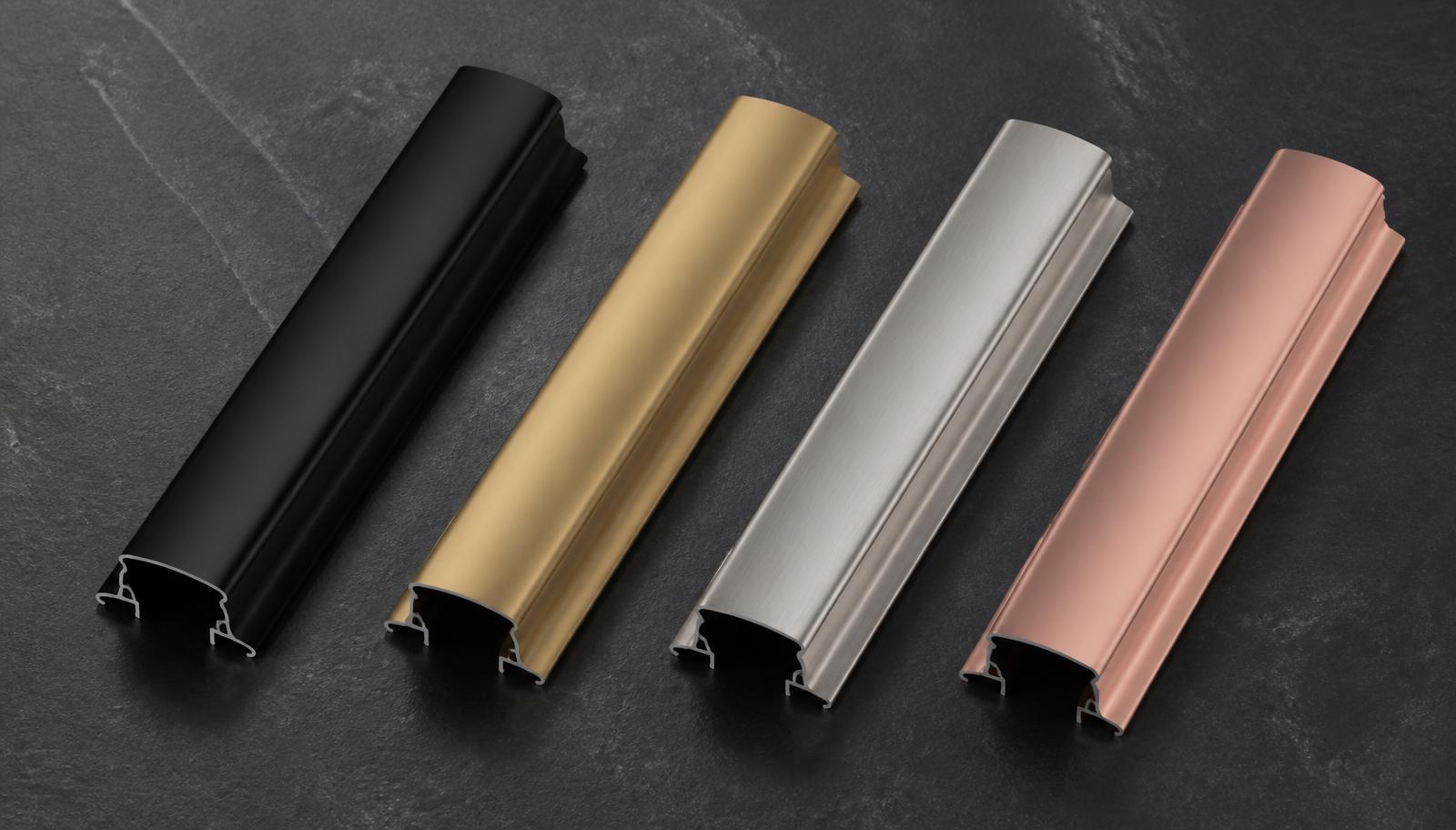 Mirano aluminium profile handle finishes Four aluminium profile handle finish samples on dark stone — matte black, champagne gold, brushed anodised silver and rose gold