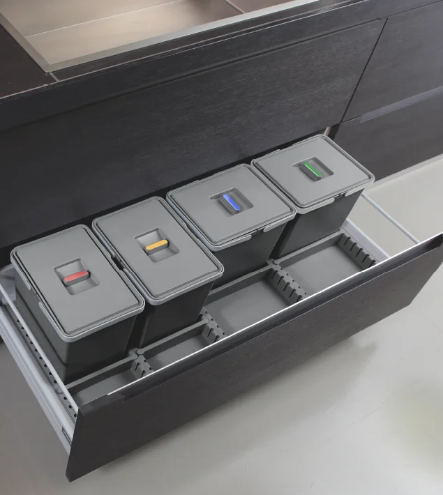 Metropolis four-bin waste system with coloured lid handles installed in a wide kitchen drawer