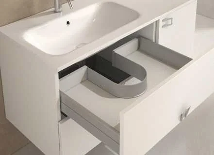 Syphon Flex fitted in a basin unit drawer Open drawer under a white basin with a grey U-shaped surround built around the plumbing space